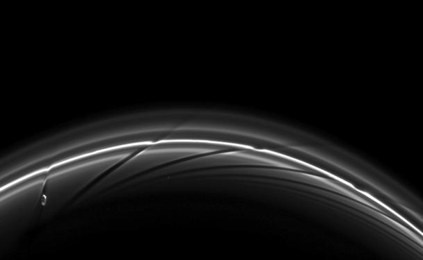 Prometheus near apoapsis carving a dark channel in the F Ring (with older channels to the right). A movie of the process may be viewed at the Cassini Imaging Team website[156] or YouTube.[157]