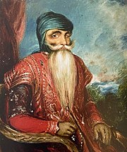 Painting of Maharaja Ranjit Singh seated and wearing red robe with natural scenery in background.jpg