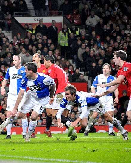 Nelsen and Morten Gamst Pedersen attempt to clear the ball in a match against Manchester United