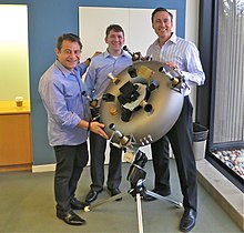 Unveiling the titanium integral space bus satellite by Planetary Resources in February 2014. The sacrificial mould for the investment casting was 3D-printed with integral cable routing and toroidal propellant tank. From left: Peter Diamandis, Chris Lewicki, and Steve Jurvetson. PlanetaryResources 3D printed satellite--201402.jpg