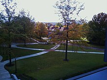 Picture of a campus quadrangle with pathways intersecting and a building in the distance