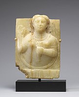 South Arabian stele, bust of female raising her hand, with the donor's name, Rathadum, written below; 1st century BC-1st century AD; calcite-alabaster; 32.1 cm (12.6 in) x 23.3 cm (9.1 in) x 3.5 cm (1.3 in); Walters Art Museum (Baltimore).