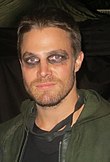 Stephen Amell, qui incarne Oliver Queen, photographié sur le plateau dans son costume de Green Arrow en 2014