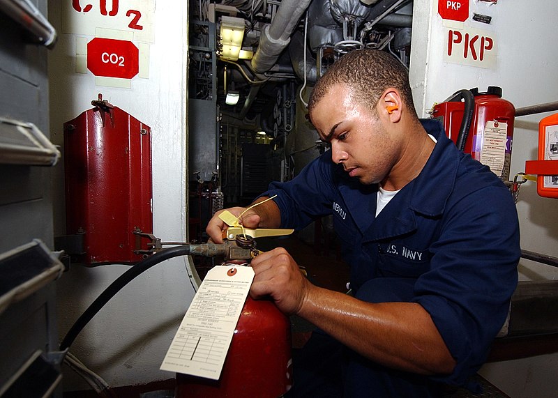 File:US Navy 040701-N-4374S-001 Fireman Alex Abreu performs a Planned Maintenance System (PMS) check on a CO2 fire extinguisher.jpg