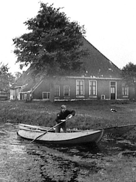 File:Zij- en voorgevel van boerderij met in het water daarvoor een jongen in een punter - Molkwerum - 20461951 - RCE.jpg