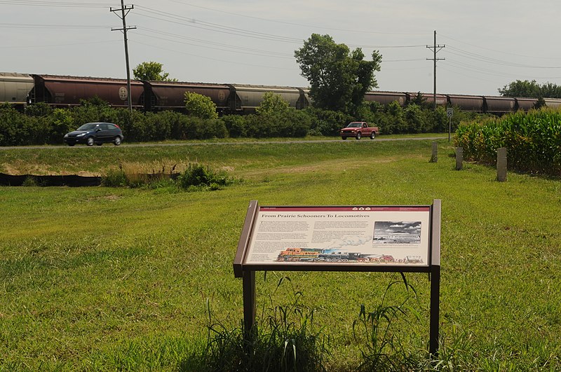 File:"From Prairie Schooners to Locomotives" wayside with train and cars in the background at Gardner Junction (c636205646364161b2da5f6dfb1b86d3).JPG