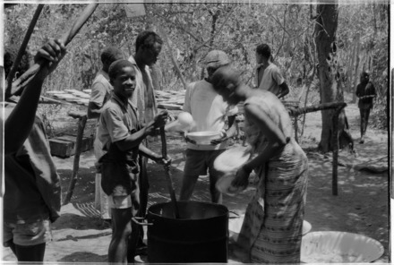 Dividing the cooked food in portions for a group meal. Campada, Guinea-Bissau, 1974.