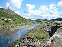 The Ystwyth looking upstream from its confluence with the Rheidol just before their combined estuary.On the left is Pendinas Hill and on the right is Tanybwlch Beach