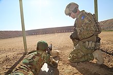 An Australian Army soldier instructing an Iraqi Ground Forces soldier at Camp Taji during the War in Iraq, 2016 An Australian soldier with Task Group Taji provides instruction to an Iraqi soldier assigned to the 71st Iraqi Army Brigade during a zeroing range at Camp Taji in January 2016.jpg