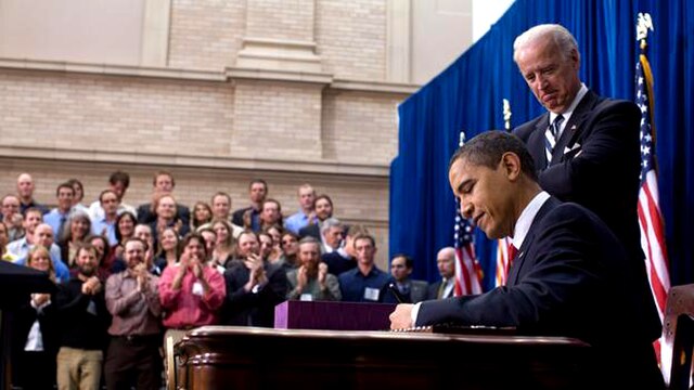 President Obama signs the ARRA into law on February 17, 2009 in Denver, Colorado. Vice President Joe Biden stands behind him.