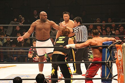 Kawada (right) and Bob Sapp (left) look at their opponents during a match in HUSTLE.