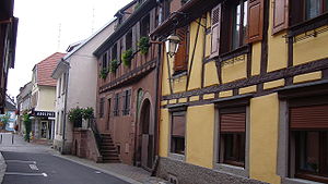 Maison à Châtenois reconstruite en 1722 par Hans Joachim Schaetti, boulanger. Porche de 1570 avec outil de tonnelier.