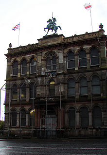 Clifton Street Orange Hall in Belfast designed by William Batt and completed in 1889, which has a protective cage. The equestrian statue on the roof by Harry Hems is the only one of King William III of Ireland, Scotland and England on any Orange hall in Ireland. Clifton street.jpg