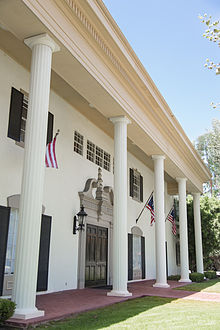 The facade of a southern colonial building, including symmetrical sets of columns, moldings, and brick walkway. Colonial Columns.jpg