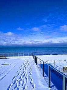 Park overlooking beach in winter near flagstand