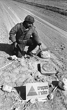 An Israeli soldier with an M19 anti-tank mine near the Jordanian border in 1982. Following the terror activity along the Jordan border, IDF units are on alert searching the area for terrorists (FL63092012).jpg