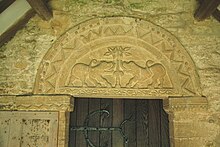 12th-century Norman tympanum of south doorway, showing the tree of life flanked by beasts Fritwell StOlave SouthTympanum.JPG