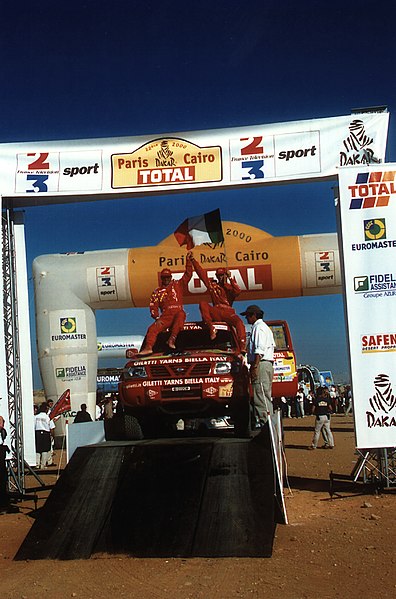 File:Gianni Lora Lamia Nissan Motorsport 22th Paris-Dakar-Cairo 2000 Podium Final Day Giza Pyramids Egypt.jpg