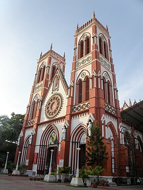 Barevná fotografie kostela s novogotickými tvary, ale v červené a bílé barvě, zvýrazňující každý prvek fasády.