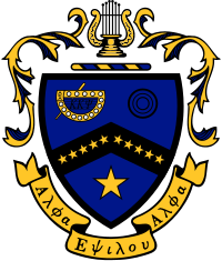 Escudo de armas de Kappa Kappa Psi.  Un escudo azul está dividido por un galón negro, en el que se colocan diez estrellas doradas: cinco en el lado izquierdo del galón, cinco en el derecho.  En el lado superior izquierdo hay una representación de la insignia de la fraternidad en oro y negro.  En la parte superior derecha hay tres círculos negros.  En la mitad inferior del escudo, hay una gran estrella dorada.  El escudo está rematado por una barra de alternancia azul y oro, sobre la que descansa una lira dorada.  Manto decorativo de oro con azul rodea el escudo.  Debajo de la cresta hay un pergamino dorado, en el que están escritas las palabras griegas "Alpha Epsilon Alpha".