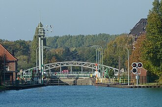 Blick mit Teleobjektiv von der Brücke am Eichenbrink zur „Hafenschleuse“ in Limmer; im Hintergrund rechts ein Gebäude der ehemaligen Hannoverschen Gummiwerke Excelsior, des späteren Continentalwerkes