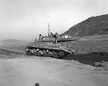 An M32B1A1 recovery vehicle backing up into a ditch after passing a bridge on the road to Hamhung during the Korean War. M32-Hamhung-19501110.JPEG