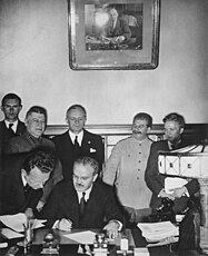 Podepisování paktu Ribbentrop–Molotov 28. září 1939. Smlouvu podepisuje Molotov, nad ním Ribbentrop, vpravo od něj Stalin.