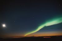 A nightsky with the moon on the left and the aurora (norther lights) on the right.