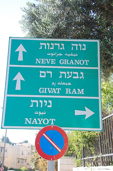 Signpost in Israel, showing directions in Hebrew, Arabic, and transliterated into Latin script.