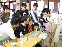 OLPC with children and developers.JPG