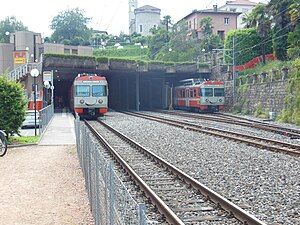Grey-and-red trains on yard tracks at station throat