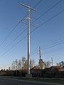 Stahlrohr-Kompaktmast mit seitlich angebrachten Isolatoren einer 230-kV-Leitung entlang einer Straße in den Vereinigten Staaten