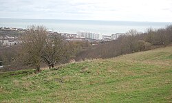 Earth bank visible of Whitehawk Camp, with the sea behind