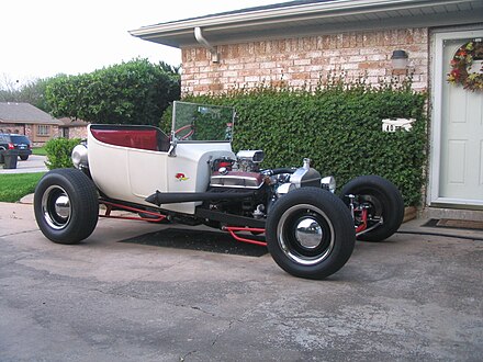 A 1923 Ford T-bucket in the traditional style with lake headers, dog dish hubcaps, dropped "I" beam axle, narrow rubber, and single 4-barrel, but non-traditional disc brakes