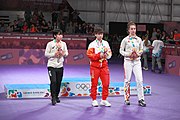 Deutsch: Tischtennis bei den Olympischen Jugend-Sommerspielen 2018: Tag 4, 10. Oktober 2018, Mädchen-Einzel, Siegerehrung - Gold: Yingsha Sun (CHN), Silber: Miu Hirano (JPN), Bronze:Andreea Dragoman (ROU)); Medaillen überreicht durch IOC-Mitglied Ching-kuo Wu (TPE), Maskottchen überreicht durch ITTF-Vize-Präsident Masahiro Maehara (JPN) English: Fencing at the 2018 Summer Youth Olympics at 10 October 2018 – Girls' single medail ceremony – Gold: Yingsha Sun (CHN), Silber: Miu Hirano (JPN), Bronze:Andreea Dragoman (ROU)); Medal presenter: IOC member Ching-kuo Wu (TPE), Mascot presenter: Vice-President Executive of the ITTF Masahiro Maehara (JPN)