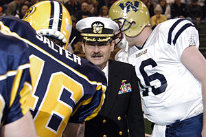 A Cavalry player shaking hands during pregame US Navy 050403-N-2115M-168 Commanding Officer, Naval Station Everett, Capt. Eddie Gardiner, shakes hands with players of the National Indoor Football League during Military Appreciation Night at the Everett Events Center, Evere.jpg