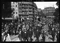 Joukko kolmivärisiä lippuja kävelyllä bulevardilla Pohjois-Pariisissa.