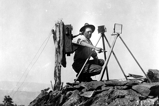 US Forest Service lookout using a Colomb shutter type heliograph in 1912 at the end of a telephone line