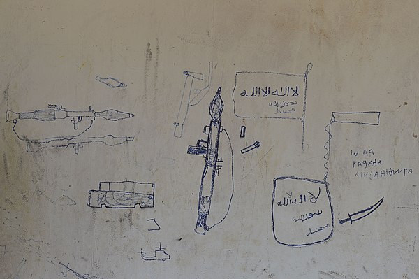 Drawings left by fighters on the walls of a building in El Baraf.