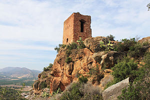 Foto de torre de pedra arruinada, com dois pisos de altura.