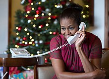 First Lady Michelle Obama reacts while talking on the phone to children across the country as part of NORAD Tracks Santa 2016. First Lady Michelle Obama during NORAD Tracks Santa 2016 (31813982566).jpg
