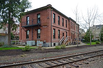 The building's south side is still passed by tracks, a freight line now owned by the Oregon Pacific Railroad. Former PRL&P Sellwood Division Office and Clubhouse - from southwest, with track (2016).jpg