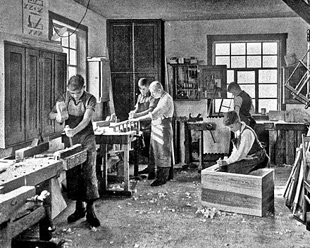 Students in a carpentry trade school learning woodworking skills, c. 1920