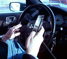 Водитель с телефонами за рулём автомобиля