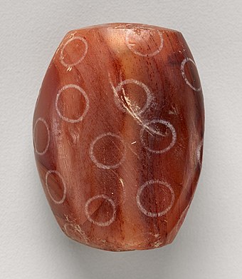 Indus Civilisation carnelian bead with white design, ca. 2900–2350 BC. Found in Nippur. An example of early Indus-Mesopotamia relations.[5]