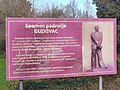 Info-tabla spomen područja sa slikom bivšeg kipa "Gudovčan" na njoj.