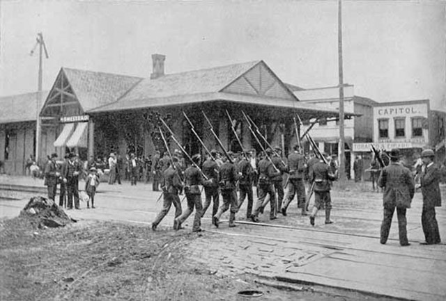 State militia passing the railroad station to disperse groups of strikers.