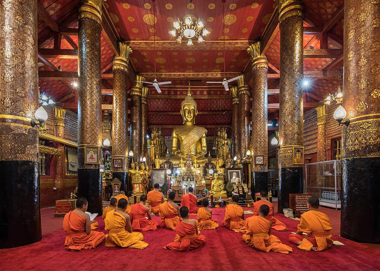 Praying bhikkhus inside Wat Mai Suwannaphumaham in Luang Prabang Laos