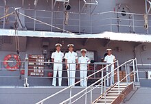 Quarterdeck of a Japanese warship. Note the watchstanders in uniform, the wooden plaque, and the proximity to the accommodation ladder. QuarterdeckKatori.jpg