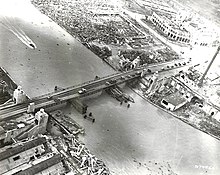 An aerial view of Manila after the Battle of Manila. The Metropolitan Theater, in the top-right corner of the photo, is damaged but still standing. Quezon Bridge, Manila - 10 July 1945.jpg
